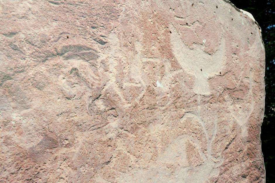 Плоский камень из красного песчаника с рисунками древних художников со сценами охоты на птиц